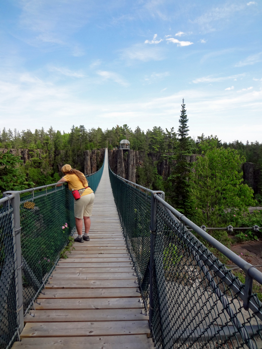 Karen Duquette is leaning over the side of the bridge